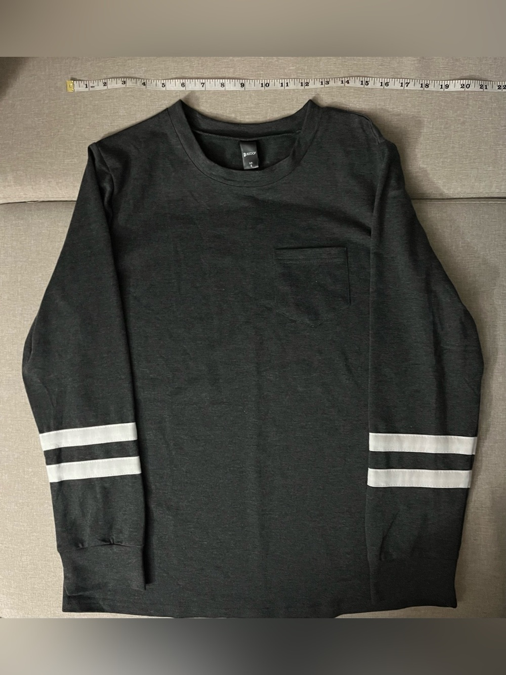 dark gray long sleeve top with white stripes on sleeves